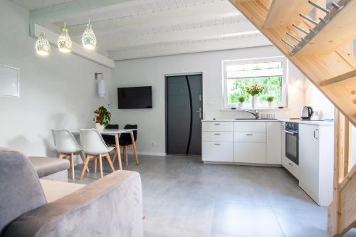 a kitchen and living room with white cabinets and a table at Gosciniec Zacisze in Chmielno