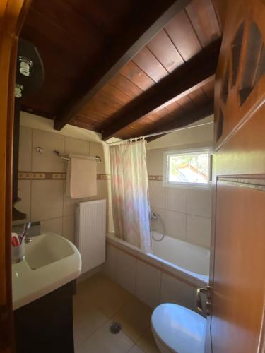 y baño con lavabo, bañera y aseo. en Manos’ Traditional Maisonette, en Aigósthena