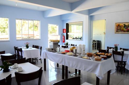 a dining room with a table with food on it at Hotel JM Ferreira in Caeté