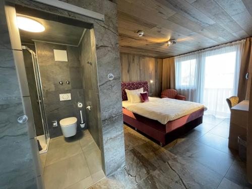 a bathroom with a bed and a shower in a room at Hotel Fohlenhof in Ampfing