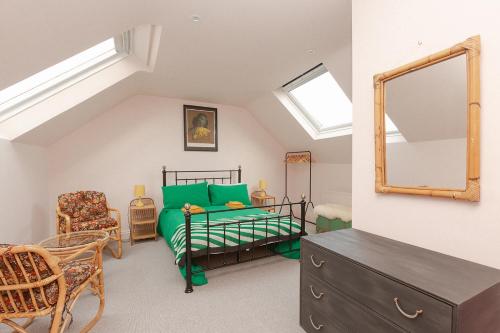 a bedroom with a bed and a mirror and a chair at Funky flat in Margate's Westbrook Bay in Kent