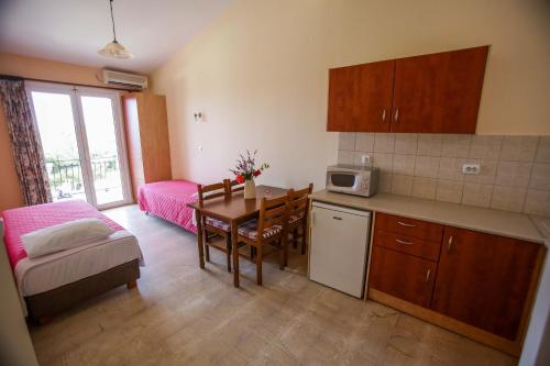 uma cozinha e sala de jantar com uma mesa e um sofá em Meraki apartments em Lassi