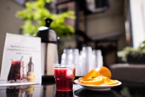a drink and a plate of oranges on a table at Opera Garden Hotel & Apartments in Budapest