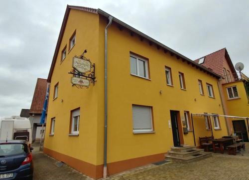 a yellow building with a clock on the side of it at Mainsommer in Kemmern