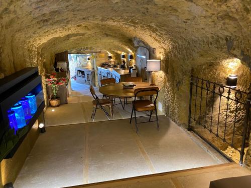 - une cuisine et une salle à manger avec une table dans une grotte dans l'établissement Le Tunnel du Moulin, à Noyers-sur-Cher