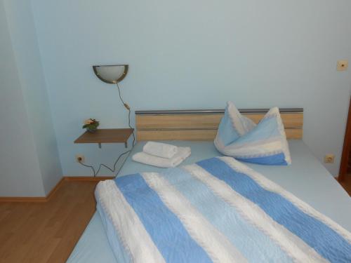 a bedroom with a bed with blue and white pillows at Pension Weinhaus Unger in Schwenningen