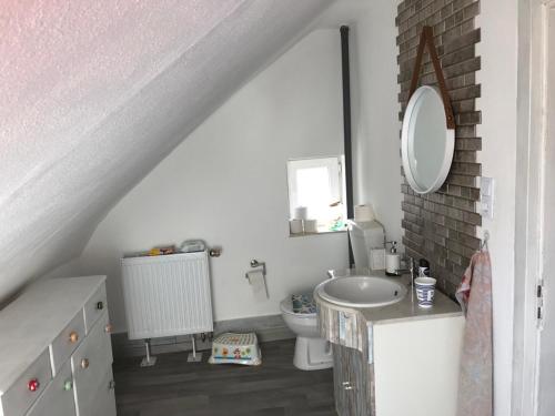 a white bathroom with a sink and a toilet at Ferienwohnung im Einfamilienhaus, Automobil und Robert Schumann Stadt Zwickau in Zwickau