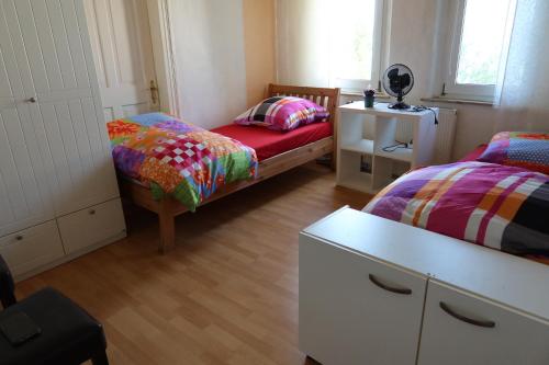 a small room with two beds and a dresser at Ferienwohnung im Einfamilienhaus, Automobil und Robert Schumann Stadt Zwickau in Zwickau