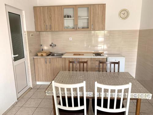 uma cozinha com mesa e cadeiras e um balcão em Colic apartments em Baošići