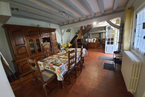 une salle à manger avec une table et des chaises dans une pièce dans l'établissement Chaumière du Château d'ô et sa mini ferme ,Gite 21couchages, à Goupillières