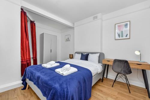 a bedroom with a bed with two towels on it at Suites by Rehoboth - Lord's - St John's Wood in London
