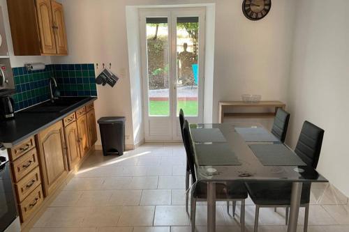 une cuisine avec une table et des chaises dans une pièce dans l'établissement « Au 10 fontaines « au cœur du vignoble 2/4 pers, à Étoges