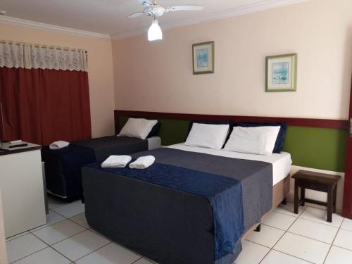 a hotel room with two beds and a couch at Pousada Caminho do Mar in Torres