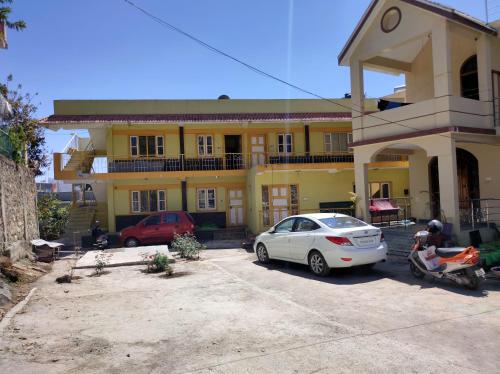 a white car parked in front of a yellow house at Misba Homestay Kodai in Kodaikānāl
