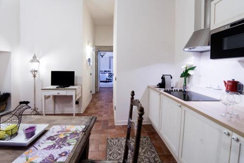 a kitchen with white cabinets and a counter top at L'Altana City House in Brescia