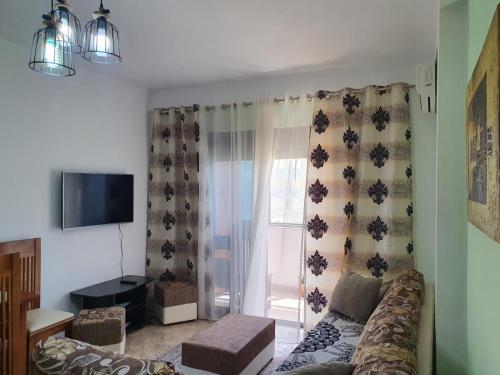 uma sala de estar com um sofá e uma janela em Roas Apartment Golem em Golem