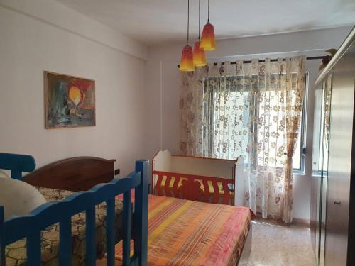 um quarto com um berço e uma janela com cortinas em Roas Apartment Golem em Golem