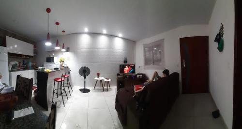 a living room with a couch and a kitchen at Casa Bella in Maragogi