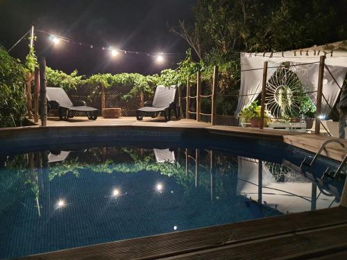 una piscina por la noche con luces y sillas en Hotel Rural La Raya 1866 en Güimar