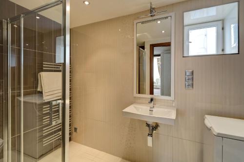 a bathroom with a sink and a mirror and a shower at Historic Centre Apartments II in Prague