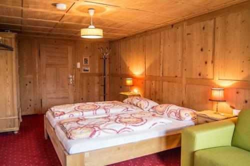 1 Schlafzimmer mit einem großen Bett und 2 Stühlen in der Unterkunft Ferienwohnung Sonnenhof in Andelsbuch