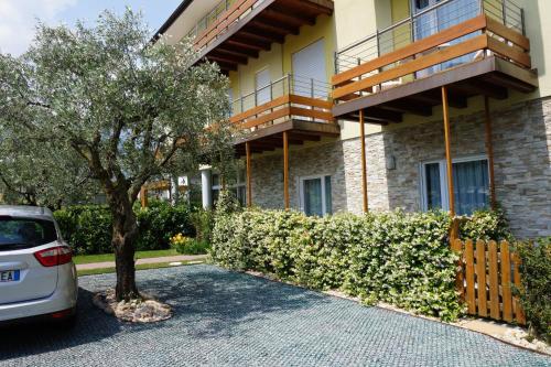 a car parked in front of a building with a tree at Residence Rivachiara (check-in at Hotel Riviera in Viale Rovereto, 95) in Riva del Garda