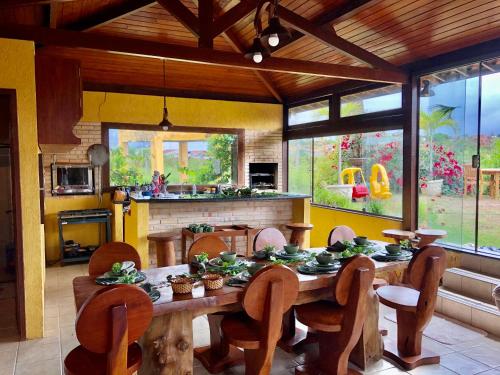 a dining room with a wooden table and chairs at Casa Santa Felicidade - Gravatá in Gravatá