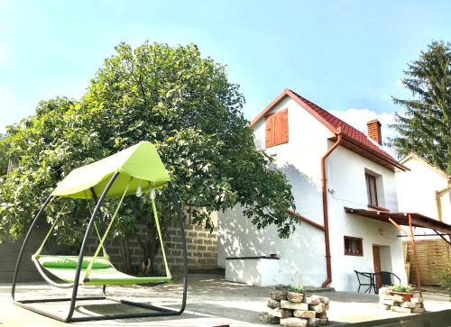 een groene paraplu in de tuin van een huis bij BorászPorta - Présház in Villány