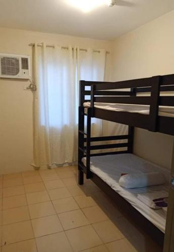 um quarto com 2 beliches e uma janela em Downtown Davao City 2 BR Condo with pool and gym em Dávao