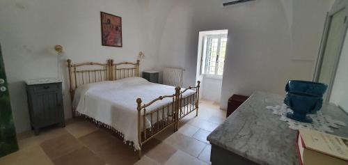 a bedroom with a bed and a table and a window at Trulli Relax a Martina Franca in Martina Franca