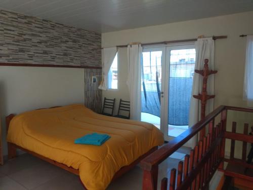 a bedroom with a large bed and a balcony at Hermoso loft con balcón y terraza in Olavarría