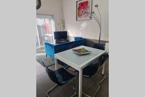 een woonkamer met een tafel en een blauwe bank bij Maison avec Jardin, proche de la plage N'3 in Équihen-Plage