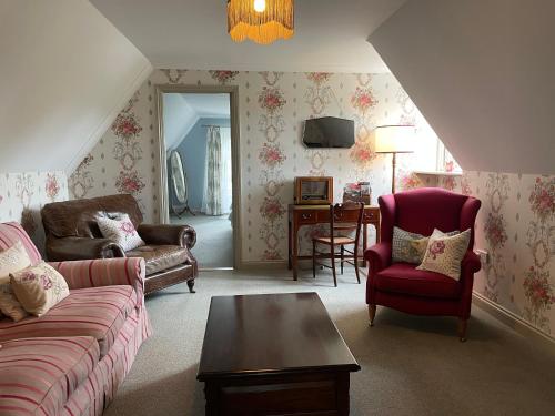 a living room with a couch and chairs and a table at Penarwyn House in Par