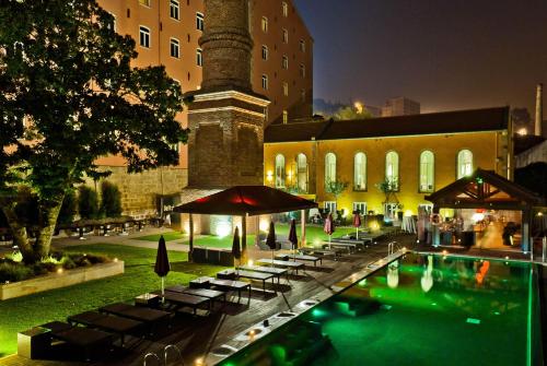 a pool in front of a building at night at Pestana Palacio do Freixo, Pousada & National Monument - The Leading Hotels of the World in Porto