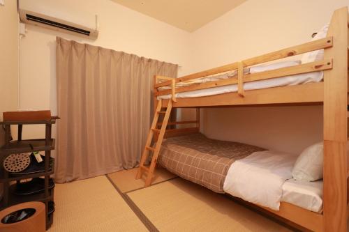 Kaigandōriにあるゲストハウス WAKURIAN-Iwatachoのベッドルーム1室(二段ベッド2組、はしご付)