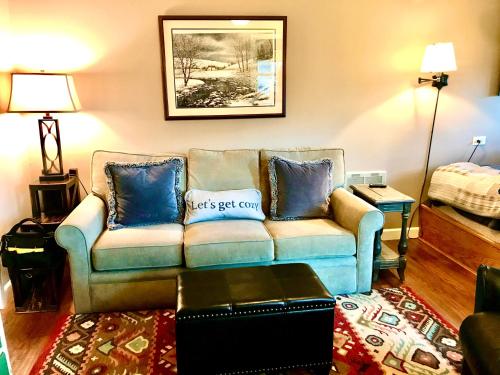 a living room with a couch with blue pillows at Beech Mountain Cozy Condo in Beech Mountain