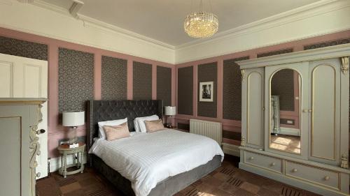 a bedroom with a bed and a chandelier at Penarwyn House in Par