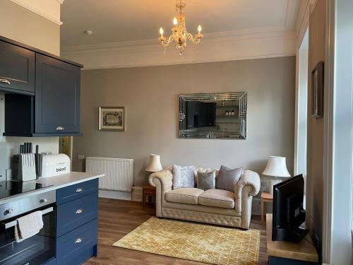 a living room with a couch and a mirror at Penarwyn House in Par