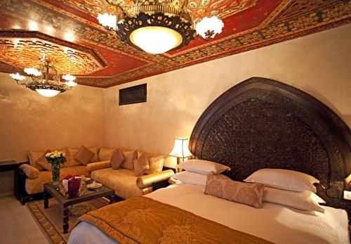 a bedroom with a large bed and a couch at Palais Shéhérazade & Spa in Fès