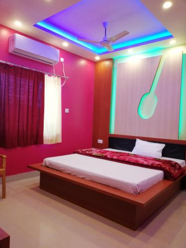 a bedroom with a bed with a pink wall at The Imperial Hotel in Rādhākishorepur