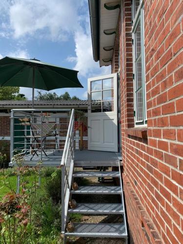 a brick building with a door and an umbrella at Deichschatz in Mittelnkirchen