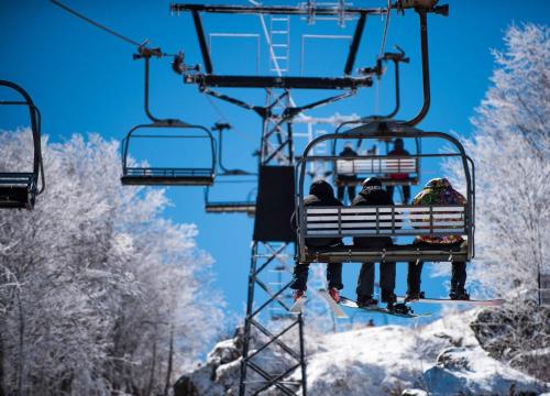 a group of people riding on a ski lift at Beech Mountain Ski Suite in Beech Mountain