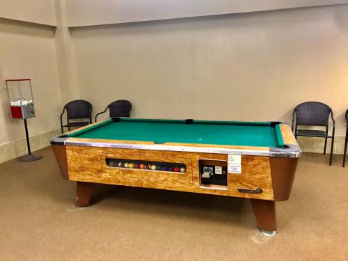 a pool table in a room with chairs at Beech Mountain Ski Suite in Beech Mountain