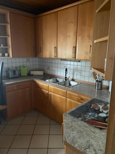 a kitchen with wooden cabinets and a sink at Erlenstr. 17 35410 Hungen in Hungen