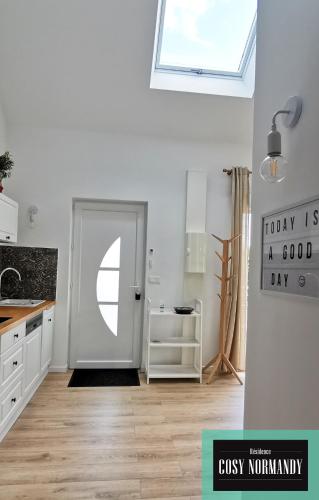 une cuisine blanche avec une porte et une fenêtre dans l'établissement Cosy Normandy - 04, à Bois-Jérôme-Saint-Ouen