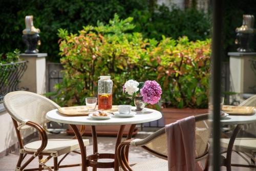 una mesa con 2 sillas y flores en un patio en Villa Ortensia, en Aci Castello