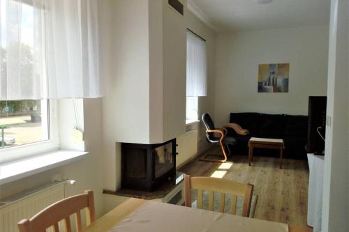 ein Wohnzimmer mit einem Kamin und einem Sofa in der Unterkunft Apartmán U parku ve Strážnici - Jižní Morava in Strážnice