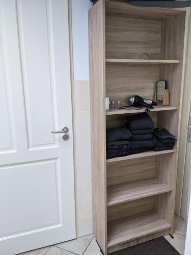 a closet with wooden shelves and a door at Logies21 Texel in Oosterend
