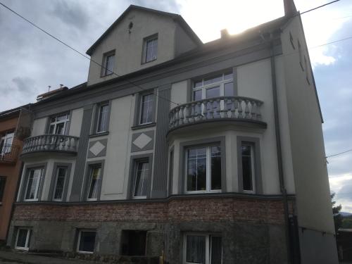 a white building with a balcony on top of it at Green Apartment House in Bielsko-Biała