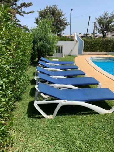 
a row of lawn chairs sitting on top of a lawn at Villa Roja Pé in Albufeira
